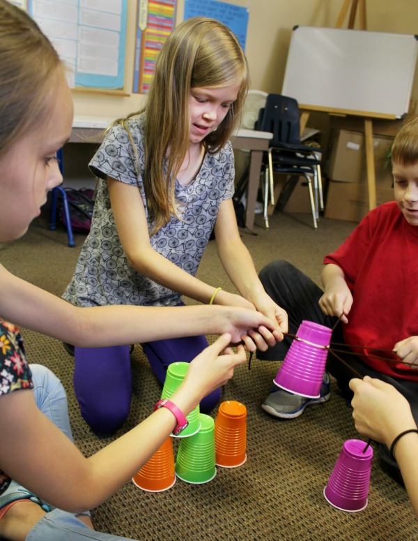 kids learning teamwork with a plastic cup challenge