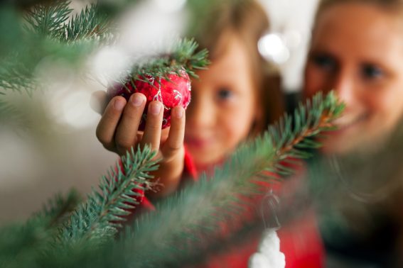 mom and daughter decorating a Christmas tree